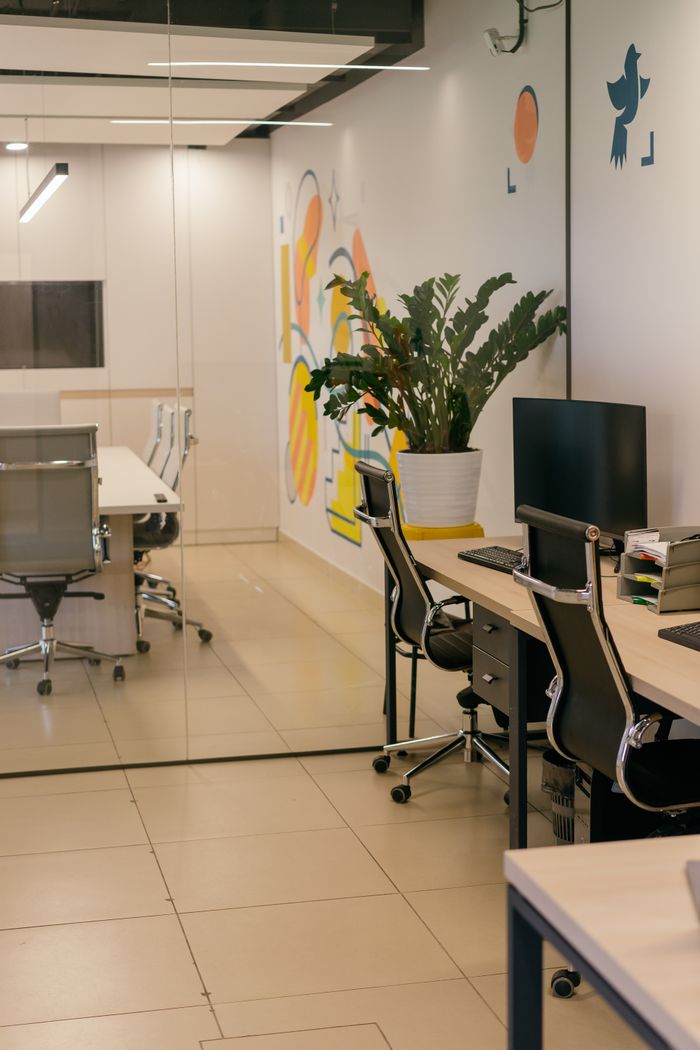 services-03 Spacious and contemporary office interior with glass partitions, stylish furniture, and vibrant wall art.